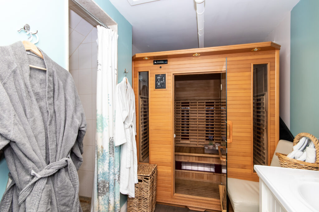 A room with two wooden sauna 's and a white bath tub.