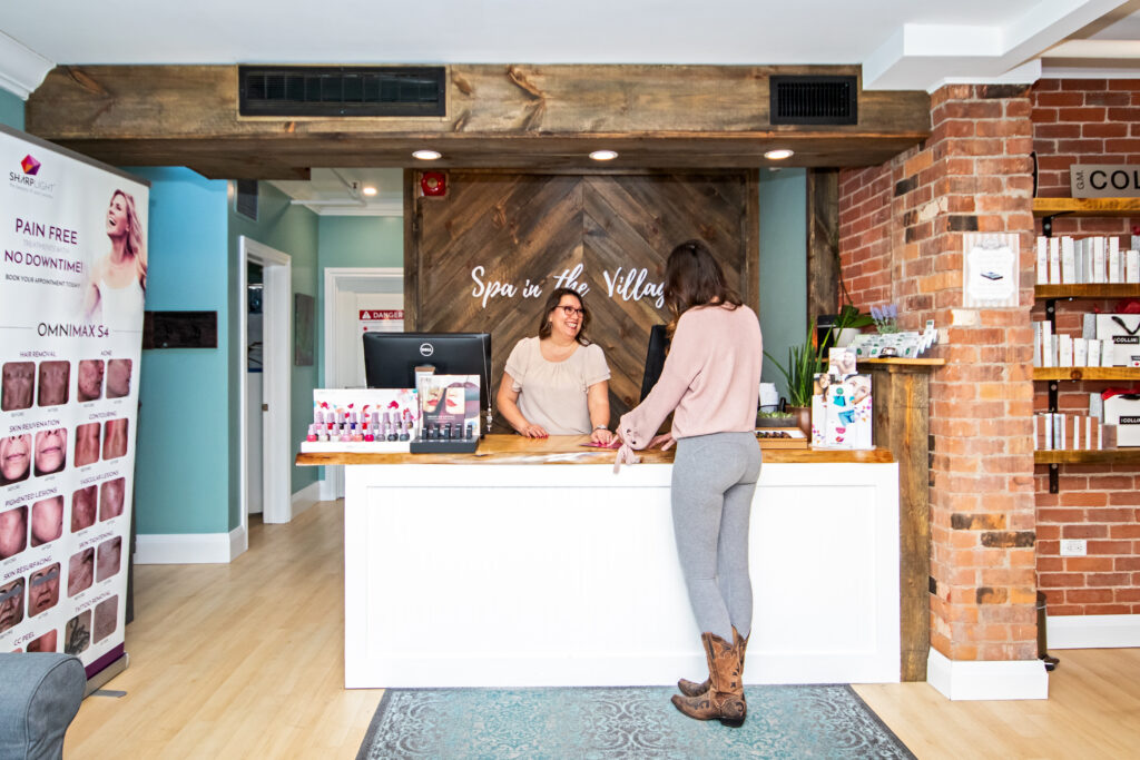 A woman standing at the front of a reception desk.